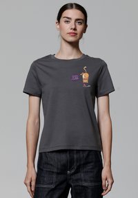 Graues Baumwoll-T-Shirt mit Rundhalsausschnitt. Mit einem Cartoon-Graphic eines Hundes mit Eiscreme und dem Text "Houston, wir haben ein Problem." Kurze Ärmel.