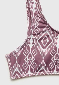 Fialový bikiny top so vzorom obsahujúcim tribálny dizajn v bielej farbe, vyrobený z hladkej tkaniny s nastaviteľnými ramienkami a prešívanými okrajmi.