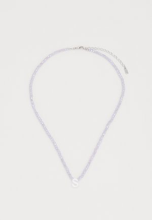 Laventelivihje kaelakee, millel on valge tähte "S" ripats ja hõbedane lukk. Omab õhukest ahelat reguleerimiseks.