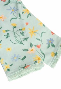 Hellgrüner Stoff mit einem Blumenmuster, das gelbe, blaue und rosa Blumen zeigt. Strukturierten gewellte Kanten verleihen dem Design Detail.