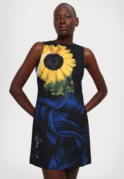Floral print dress featuring a large sunflower design in yellow and black on a dark background, with blue abstract brushstroke accents.