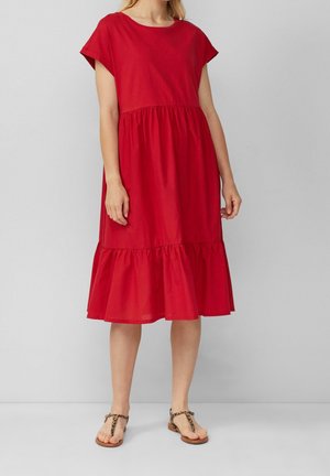 Rød bomulds kjole med korte ærmer, rund halsudskæring og tiered flæsekant. Teksturstof; parret med leopard mønstrede sandaler.