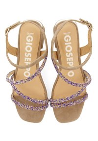 Sandalias de tacón alto en color beige con múltiples correas brillantes que presentan cuentas moradas y transparentes, tacón de bloque sólido y cierre de hebilla en el tobillo.