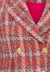 Dubbelzijdig blazer in een multicolor tweedstof met oranje, roze en witte tinten, afgewerkt met gouden knopen en een roze voering.