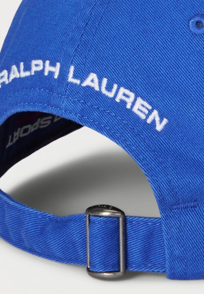 Gorra de béisbol azul real con el logotipo bordado en blanco "RALPH LAUREN" y una hebilla de ajuste metálica plateada en la correa. Tela texturizada.