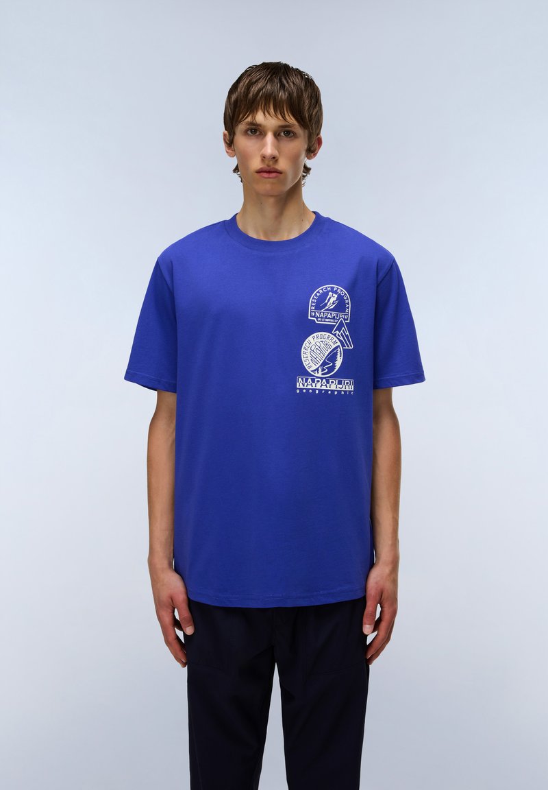 Blue cotton T-shirt with a round neckline, featuring three white graphic prints, including text and logo details on the front.