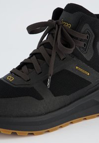 Chaussure de randonnée noire imperméable avec un empeigne en mesh texturé, un talon renforcé et une semelle en caoutchouc dotée d'un motif en crampons pour une adhérence optimale.