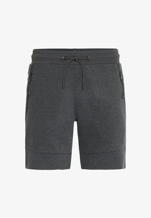 Harmaat urheilushortsit, joissa on naru vyötäröllä, vetoketjulliset sivutaskut ja sileä, joustava rakenne. Puoliväliin reisiin ulottuva malli.