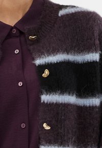 Textúrált, csíkos kardigán sötétlila, fekete és világoskék színben, aranyszínű díszegységekkel, puha, bolyhos anyagból.