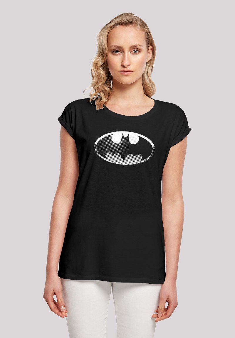 Svart t-skjorte med korte ermer laget av bomull, med et hvitt Batman-logo med prikkemønster foran. Glatt tekstur, avslappet passform.