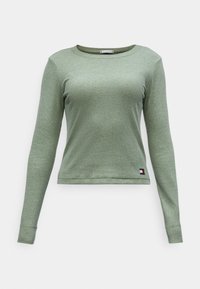Groene lange mouwen geribbelde sweatshirt met een ronde halslijn, aansluitende pasvorm en klein logo-opdracht aan de zoom. Zachte textuur en lichtgewicht materiaal.
