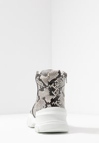 Botki kostkowe w wzór wę�żowej skóry, z teksturowanym szaro-czarnym wykończeniem, białą podeszwą platformową oraz bocznym zamkiem błyskawicznym.