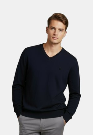 Maglione girocollo a V blu navy realizzato in tessuto morbido, con finitura strutturata e un piccolo logo sul petto. Maniche lunghe e polsini aderenti.