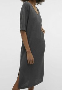 Abito lavorato a maglia grigio carbone con scollo a V, maniche corte, spacchi laterali e vestibilità ampia. Tessuto testurizzato con un sottile motivo a intreccio.