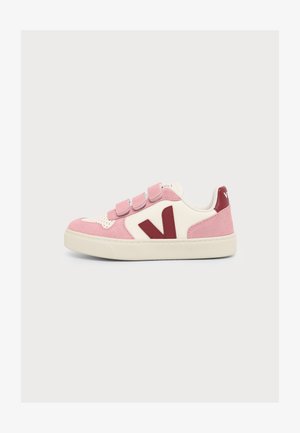 Low-top sneaker met roze suède en wit leer, drie roze klittenbandriemen, rood "V" logo en off-white zool.