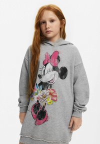Graues Sweatshirtkleid mit einem grafischen Bild eines Cartoon-Charakters und floralen Akzenten. Weicher Stoff, lässige Passform und ausgefranste Saumdetails.