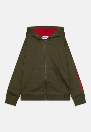 Olivgrüne Kapuzenjacke mit Reißverschluss und rotem Innenfutter sowie großem rotem Logo-Schriftzug auf dem linken Ärmel. Mit Fronttaschen und gerippten Bündchen ausgestattet.