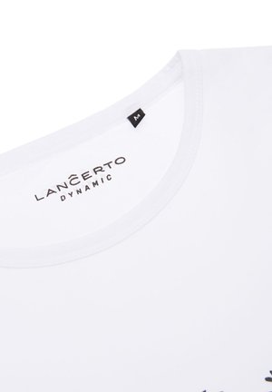 Biała koszulka z krótkim rękawem i okrągłym dekoltem, z czarnym nadrukiem "LAN ČERTO DYNAMIC" oraz czarną metką rozmiaru.