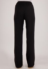 Zwarte, wijde broek met een elastische tailleband. Gladde textuur, rechte snit, geen zichtbare zakken of patronen. Alleen achteraanzicht.