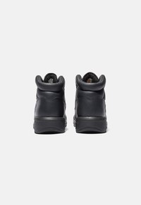 Sneakers alte in pelle nera con tacco arrotondato, superficie testurizzata e cuciture rinforzate sul retro. Suola in gomma resistente.