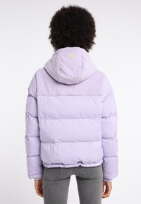 Lila pufferjacka med en corduroyhuva, elastiska ärmslut och nederkant. Har en dekorativ patch på ryggen. Slät textur med kviltad design.