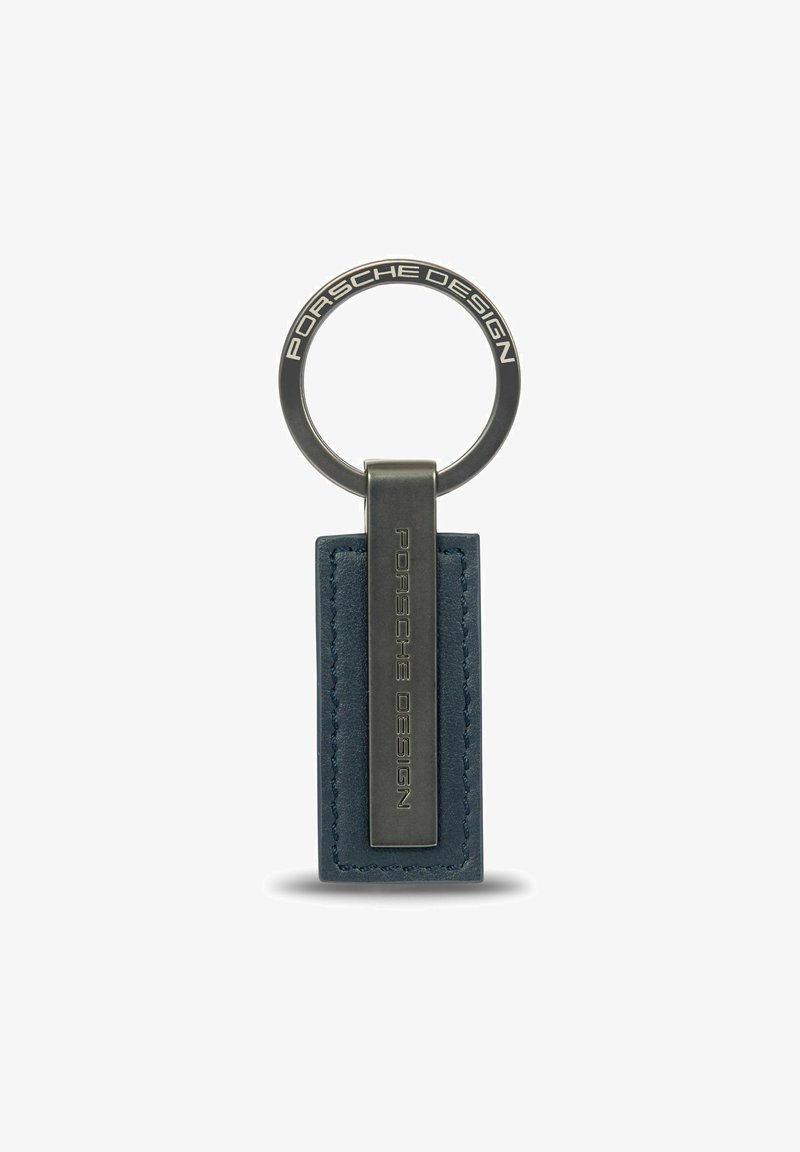 Porte-clés avec étiquette en cuir bleu rectangulaire et clip en métal gravé avec "Porsche Design," attaché à un anneau en métal rond également gravé de texte.