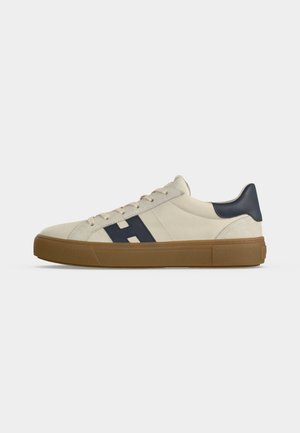 Kremowe niskie sneakersy z gumową podeszwą, granatową zakładką na pięcie i granatowym logo "H" po boku, pokazane z profilu prawego na białym tle.