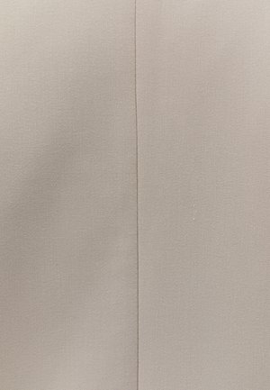 Beige stof med en lodret søm, der løber ned midten, der viser vævet diagonalt twillmønster og lette folder på begge sider.