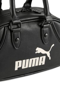 Schwarz synthetische Handtasche mit zwei oberen Griffen, mit einem großen weißen "PUMA"-Logo und einem springenden Puma-Symbol an der Seite.