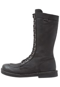 Botte noire en cuir montant jusqu'au genou avec un bout arrondi, un laçage à l'avant et des œillets en métal. Présente une finition texturée et une semelle en caoutchouc robuste.