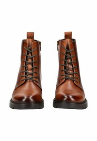 Botas de tobillo de cuero marrón con un acabado suave. Con cordones delante, cremallera lateral y una suela de goma negra con dibujo.