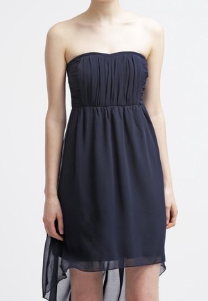 Donkerblauwe strapless jurk van zachte stof, met een geplooide bustier en een vloeiende high-low zoom. Zonder zichtbare patronen of metaalwerk.
