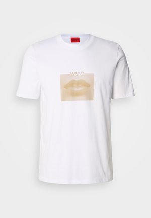 Witte katoenen t-shirt met een grote, beige afbeelding van lippen binnen een dotted vierkant, met de tekst "HUGO" boven het ontwerp.