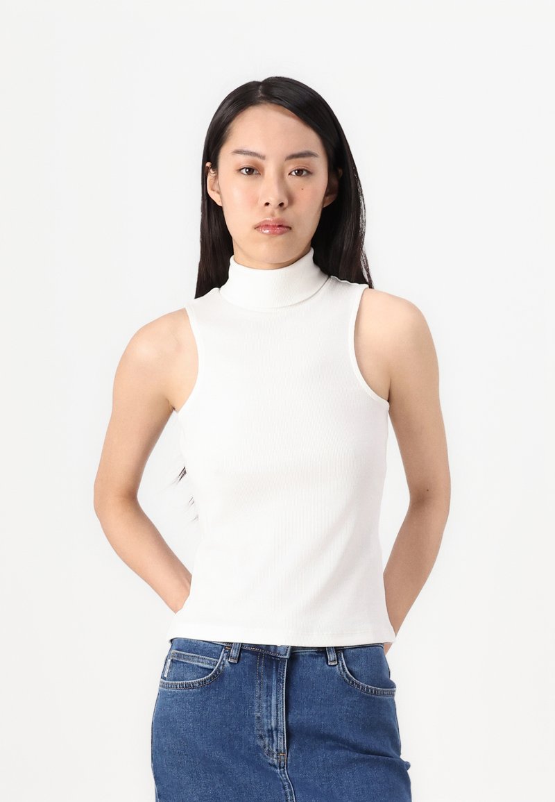 Top senza maniche bianco a coste con colletto alto, design aderente, texture liscia e senza motivi o accessori visibili.