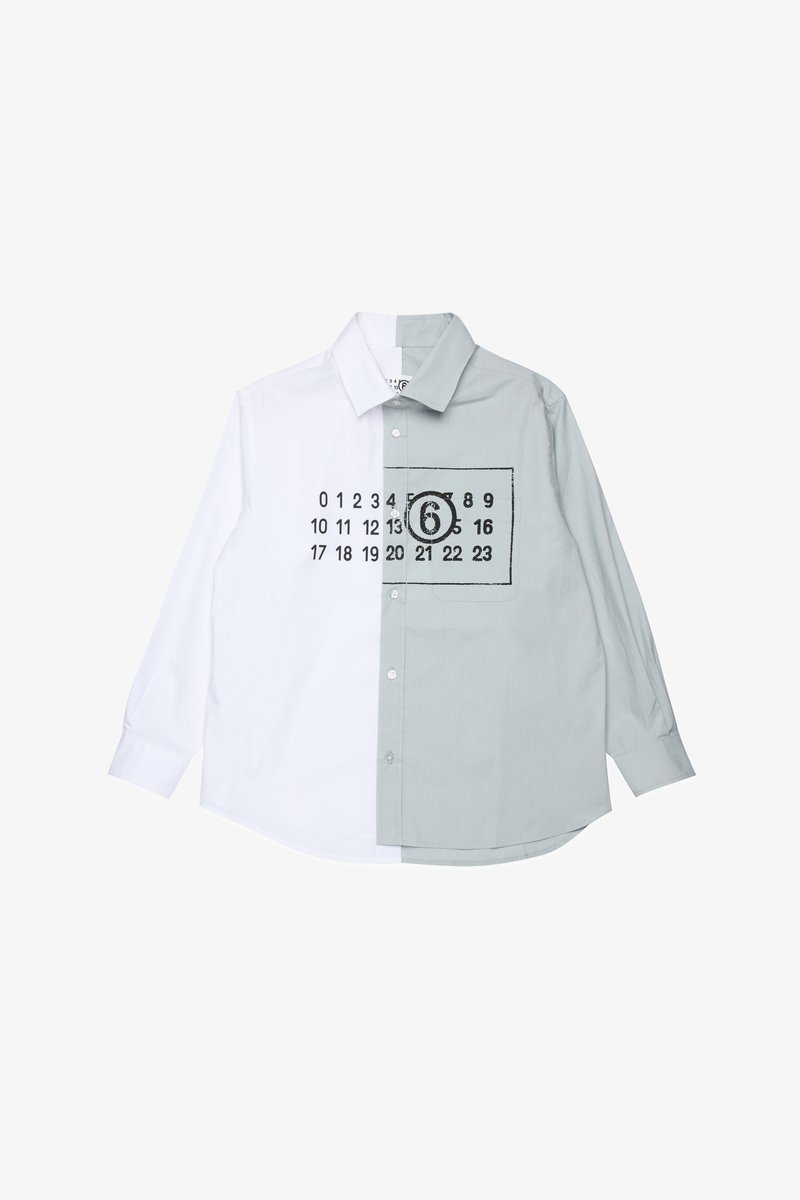 Mygtukų marškiniai su padalinto dizaino; balta kairė pusė, šviesiai pilka dešinė pusė su atspausdintais juodais numeriais ir kišenės detale.