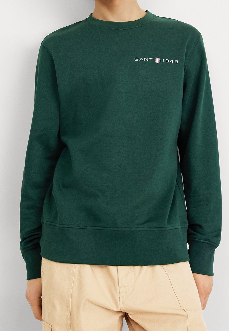 Grön bomullsSweatshirt med rundad halsringning, långa ärmar och ribbade fållar. Har den broderade texten "GANT 1949" i vitt.