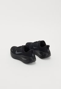 Paire de chaussures de course Nike ZoomX noires avec tiges en mesh et semelles amorties, vues de dos sur fond blanc.