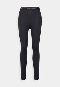 Leggings neri Calvin Klein realizzati in un tessuto liscio e elastico. Presentano un colore uniforme, una vestibilità aderente e una fascia elastica con marchio.