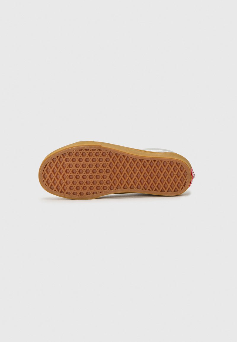 Schuhsohle mit einem Wabenmuster aus braunem Gummi. Der obere Rand hat einen weißen Abschnitt mit rotem Branding nahe der Ferse. Flaches Profil-Design.