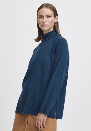 Strickpullover mit Rollkragen in Tiefblau. Merkmale sind lange Ärmel, eine lockere Passform und seitliche Schlitze für zusätzliche Details. Glatte Textur.