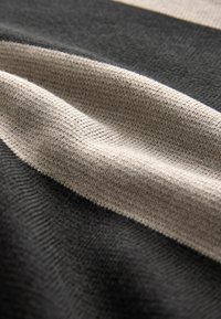 Tissu tricoté à rayures horizontales en gris foncé, gris clair et beige. La texture semble douce et lisse avec un motif cohérent.
