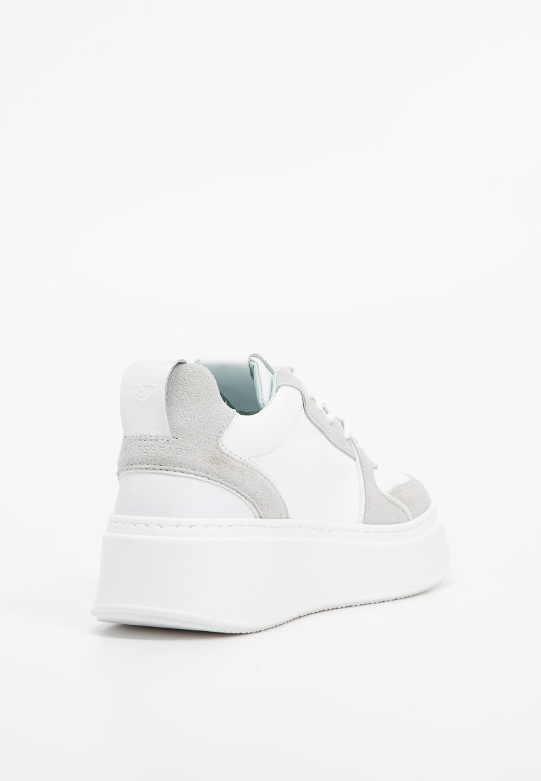 Zapatilla blanca y gris con texturas de cuero suave y ante, que presenta una suela blanca gruesa y un diseño minimalista con cordones.