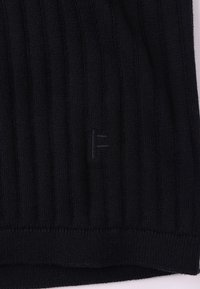 Μαύρο ριμπ ύφασμα πλεκτό με υφή και μικρή ανάγλυφη λεπτομέρεια λογότυπου. Διαθέτει εφαρμοστό, ελαστικό σχέδιο.