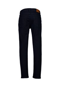 Tummansininen farkkuhousu, jossa on slim fit -leikkaus, standardi viisi-taskumalli sekä ruskea nahkalaatta takavöissä.