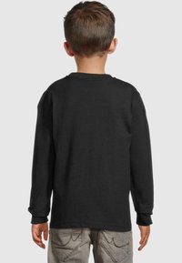Schwarzes langärmliges T-Shirt aus Baumwolle mit Rundhalsausschnitt und gerippten Bündchen, von hinten an einem Kind gezeigt.