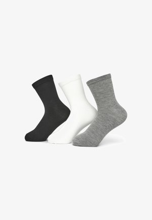 Tre paia di calzini alla caviglia: neri, bianchi e grigi. Ognuno presenta un risvolto a costine e una superficie liscia, progettati per un uso casual.