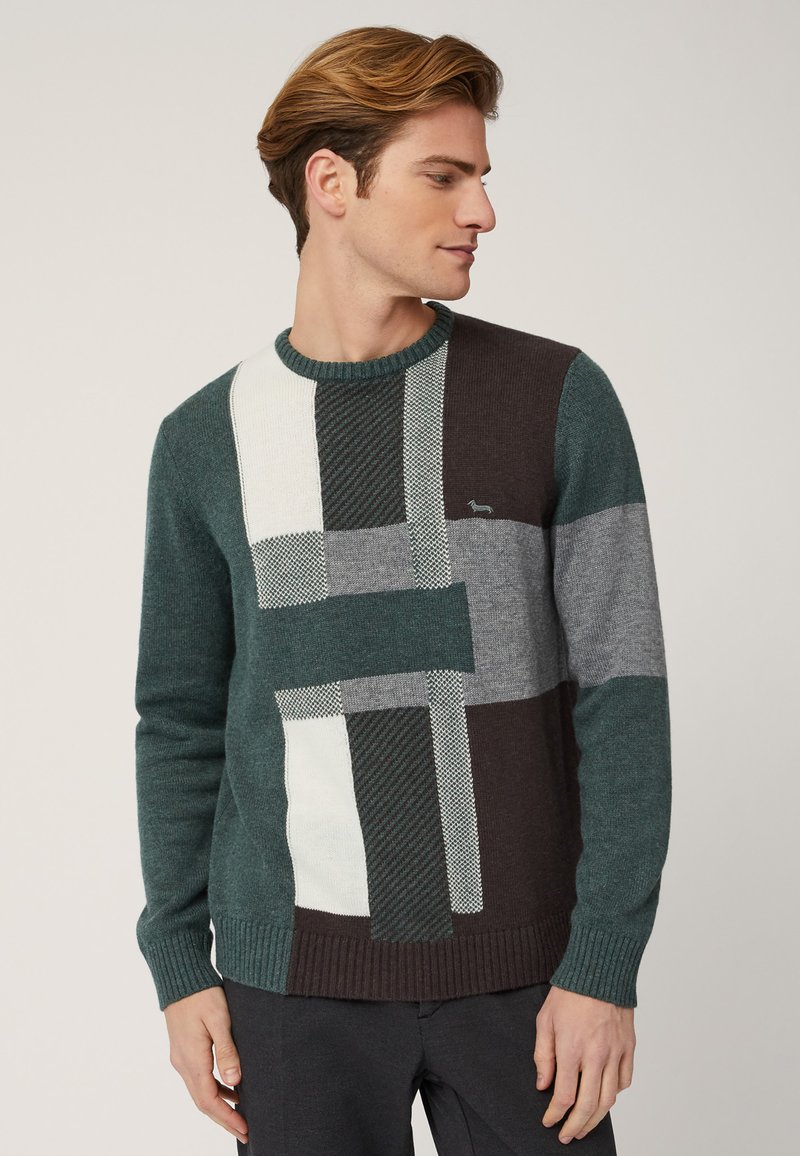 Maglione a righe verdi, grigie e bianche con un punto testurizzato, caratterizzato da forme geometriche e un colletto e polsini a coste. Piccolo logo sul petto.