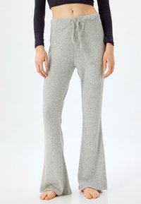 Grijze geribbelde gebreide broek met een trekkoord in de taille en uitlopende benen, gemaakt van zacht materiaal voor comfort.