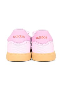 Para różowych sneakerów Adidas z perforowaną teksturą, pomarańczowym logo na zapiętku i brązowymi gumowymi podeszwami, pokazana z tyłu na białym tle.