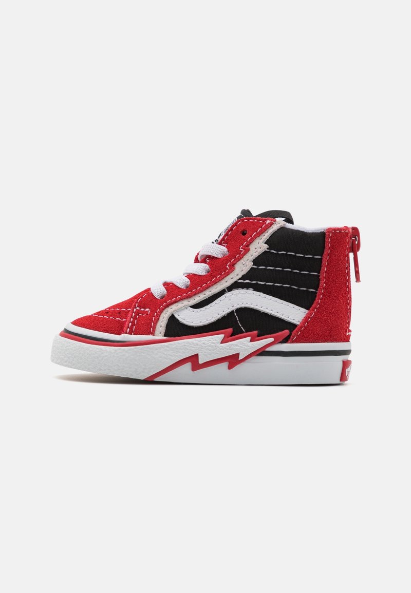Baskets montantes rouges et noires avec des lacets blancs, une bande latérale blanche et un motif en zigzag rouge sur la semelle blanche.